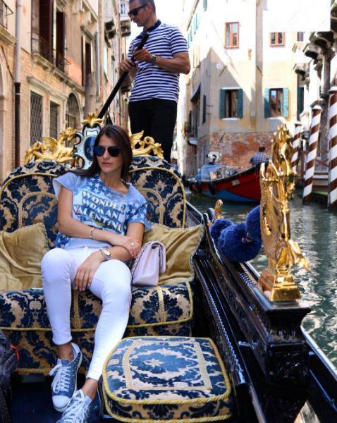 Η όμορφη Δήμητρα Μέρμηγκα απολαμβάνει μια βόλτα με γόνδολα μαζί με το σύντροφό της στα γραφικά κανάλια της Βενετίας. Στη φωτογραφία φοράει το μπλουζάκι που την ενέπνευσε να σχολιάσει ότι "η γυναίκα-θαύμα είναι στη Βενετία"