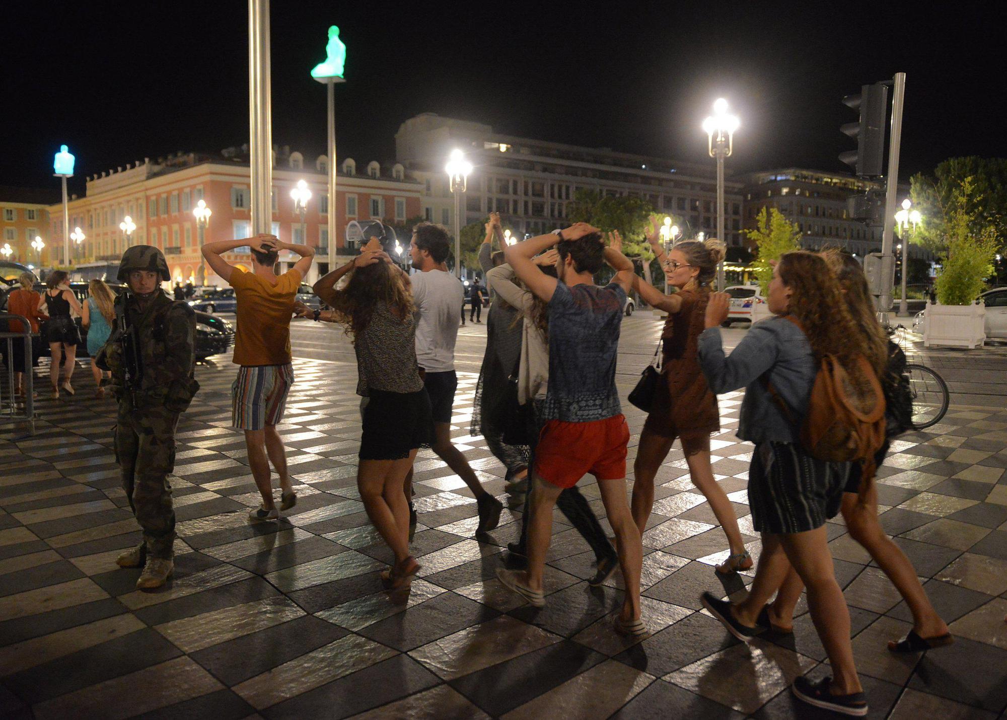 Άνθρωποι διασχίζουν το δρόμο, καθώς ένα Γάλλος στρατιώτης ασφαλίζει την περιοχή. 15/7/2016, Νίκαια, Γαλλία