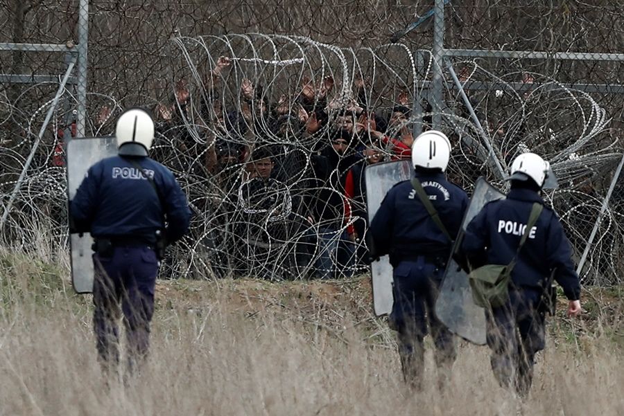 αστυνομικοί στα σύνορα του Έβρου κοιτούν μετανάστες