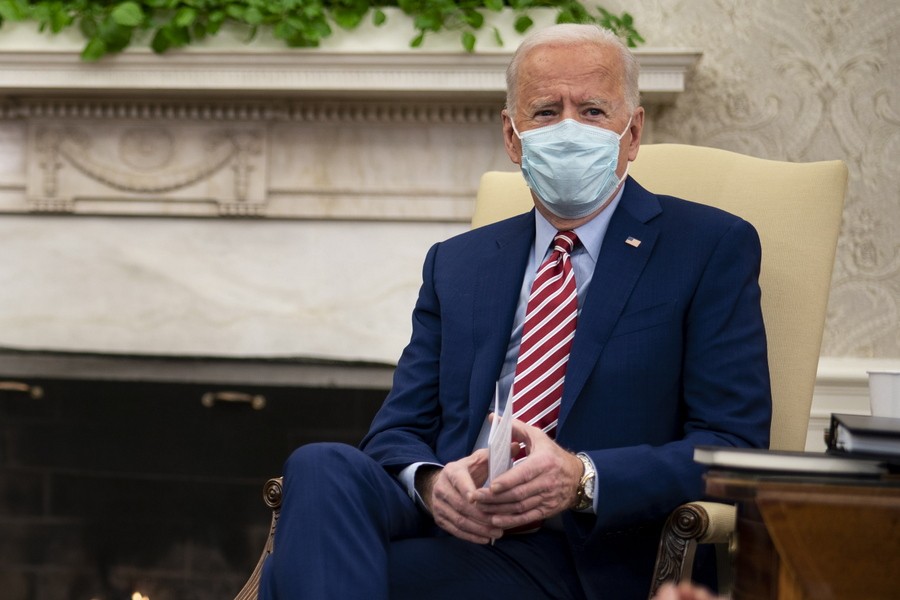 O πρόεδρος των ΗΠΑ Τζο Μπάιντεν σε καρέκλα στον Λευκό Οίκο φορώντας μάσκα προστασίας