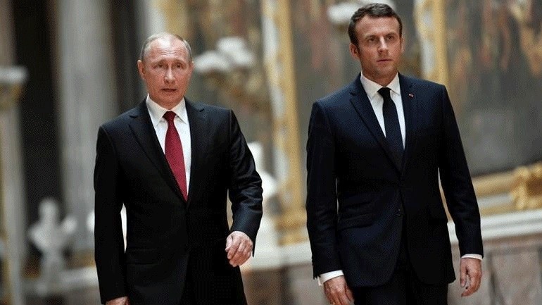Ο Βλαντίμιρ Πούτιν (αριστερά) και ο Εμανουέλ Μακρόν (δεξιά) καθώς περπατούν