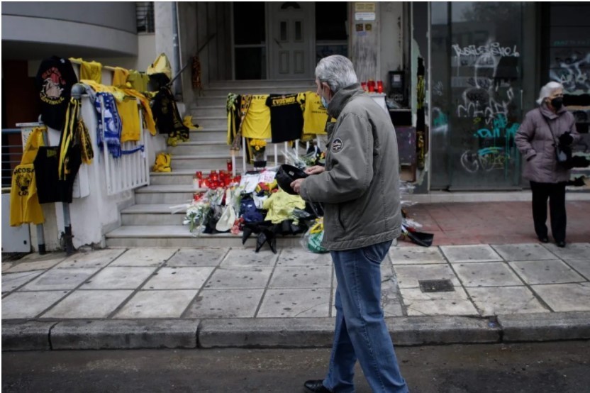 Άνθρωπος με λουλούδια στο σημείο της δολοφονίας του 19χρονου Άλκη