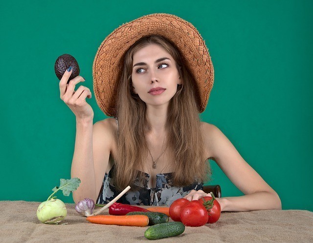 Γυναίκα με καπέλο κρατάει λαχανικά