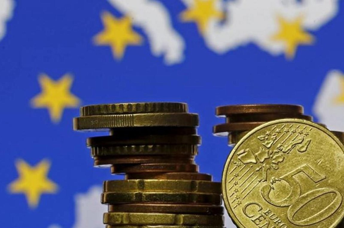 Ελληνικό νόμισμα μπροστά από την σημαία της Ευρωπαϊκής Ένωσης