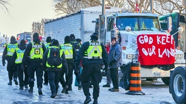 Ομάδα αστυνομικών μπροστά από φορτηγό αντιεμβολιαστών διαδηλωτών στον Καναδά