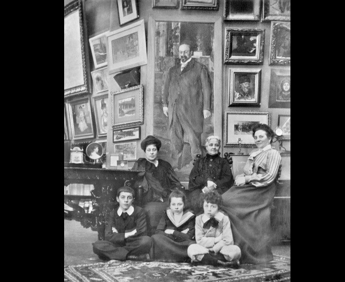 Η σύζυγος του Μορόζοφ με τα παιδιά της μπροστά σε έναν πίνακα που απεικονίζει τον σύζυγό της (1903 ή 1904)