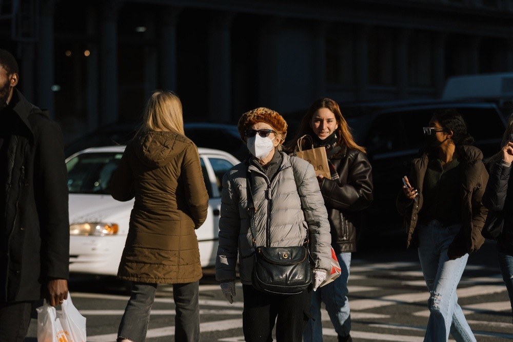 Κόσμος περπατάει στο δρόμο με μάσκα προστασίας κατά της Όμικρον 2