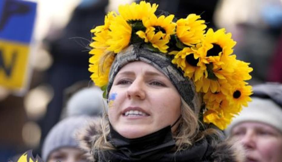 2.Διαδηλώτρια με ηλιοτρόπια σε ένδειξη συμπαράστασης στον ουκρανικό λαό