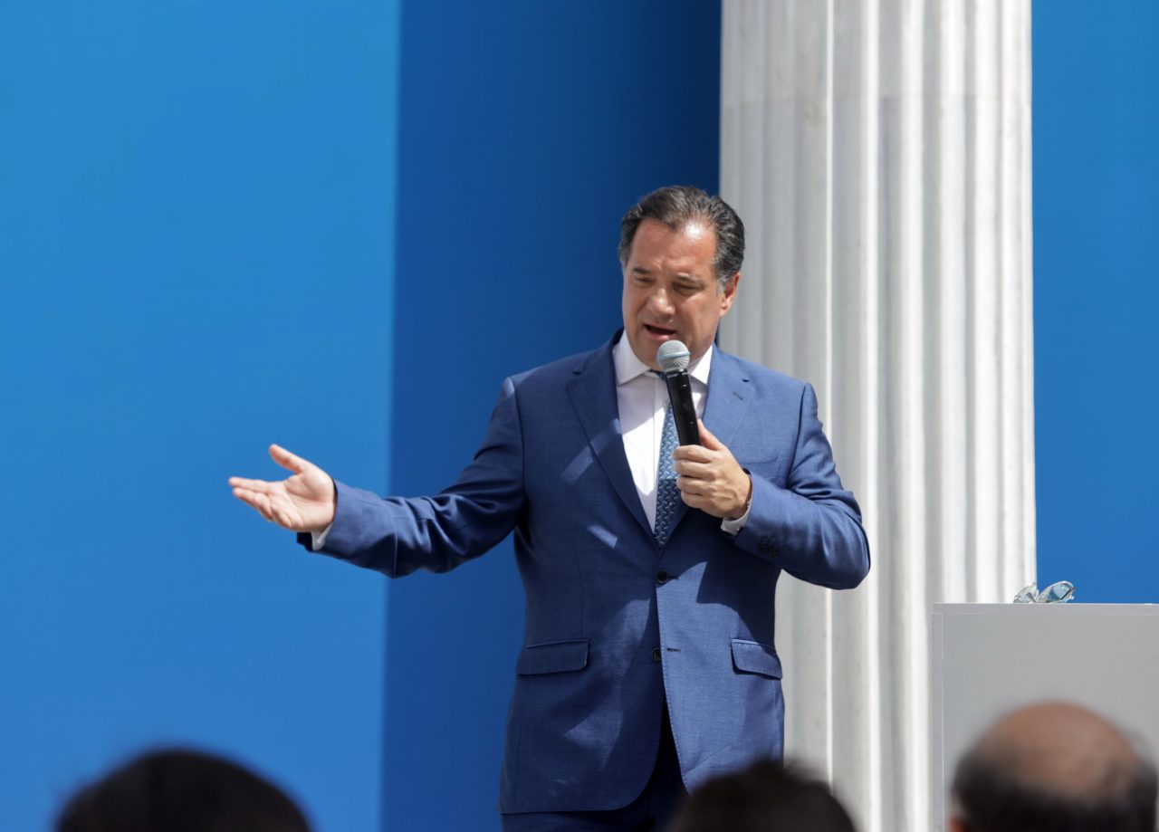 Ο υπουργός Ανάπτυξης Άδωνις Γεωργιάδης μιλά όρθιος στο μικρόφωνο σε εκδήλωση για το Growing Together μπροστά σε κοινό