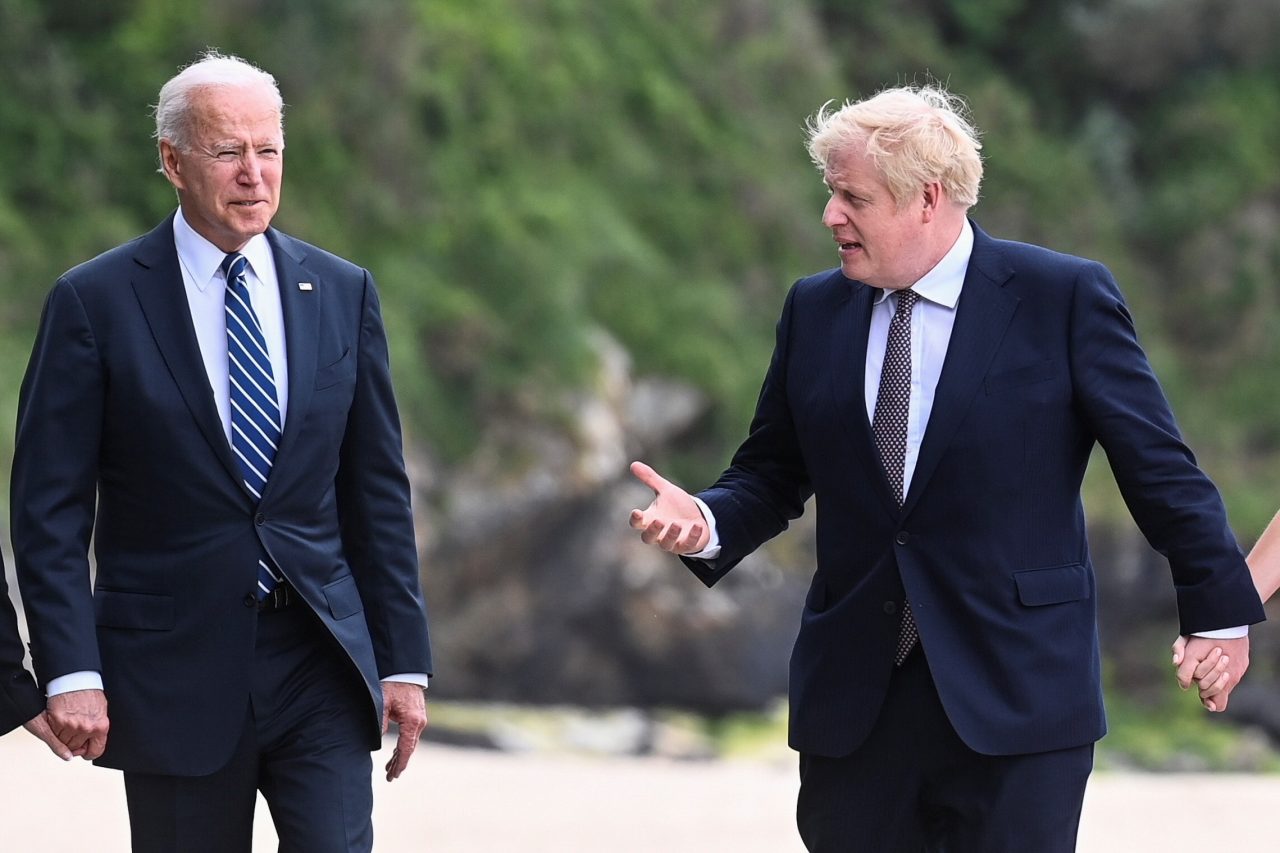 Ο Τζο Μπάιντεν και ο Μπόρις Τζόνσον περπατούν και συνομιλούν πριν από συνάντηση των G7 στη Βρετανία