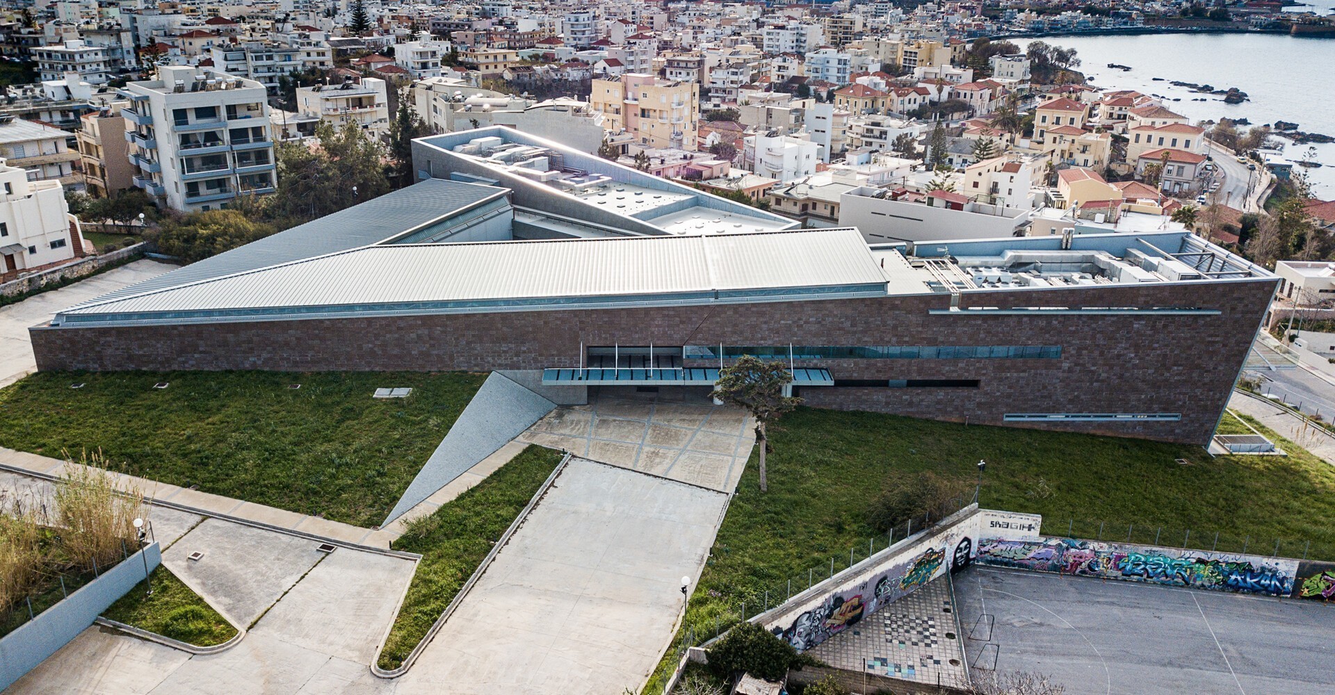 Το νέο Αρχαιολογικό Μουσείο Χανίων με θέα τη θάλασσα. Διακρίνονται οι δύο βασικοί μονολιθικοί όγκοι και το αίθριο μεταξύ τους