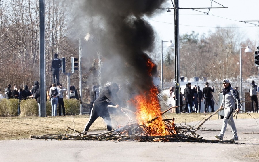 People burn branches to block a road during riots in Norrkoping, Sweden, 17 April 2022. The unrest was triggered following statements by the leader of the far-right political party Hard Line, Danish-Swedish politician Rasmus Paludan, who had already sparked outrage after burning a copy of the Koran on 14 April in a heavily-populated Muslim area in the town of Linkoping. Paludan announced he would return to Norrkoping and Linkoping to carry out more of such acts. EPA/Stefan Jerrevang