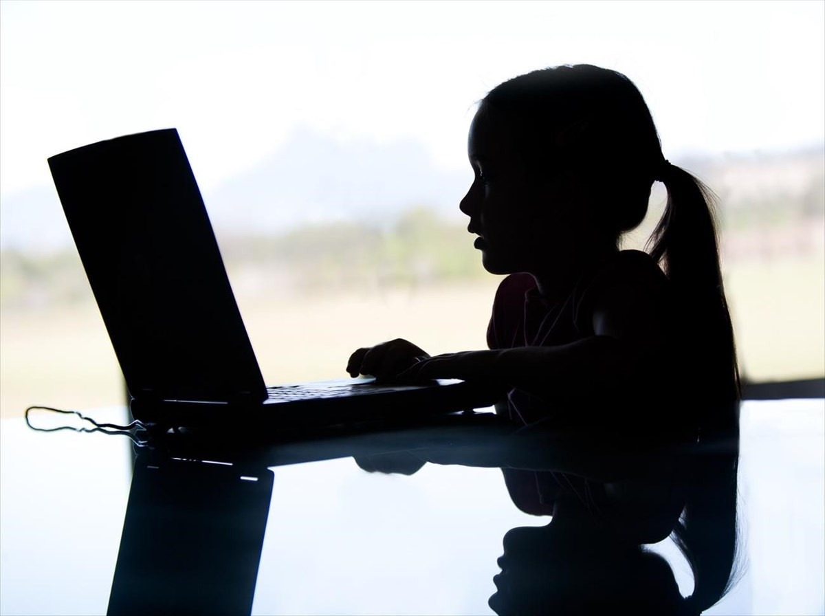 Κοριτσάκι κάθεται μπροστά στον υπολογιστή (Κομισιόν: Νέοι κανόνες για την καταπολέμηση της σεξουαλικής κακοποίησης παιδιών στο διαδίκτυο)