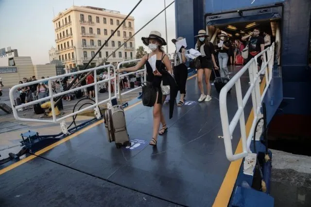 Γυναίκα αποβιβάζεται από το πλοίο φορώντας μάσκα προστασίας έναντι της COVID-19