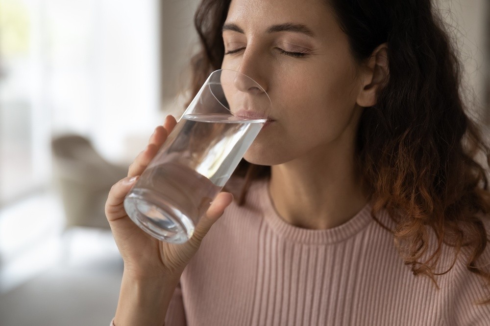 Γυναίκα πίνει νερό για να αποφύγει την αφυδάτωση
