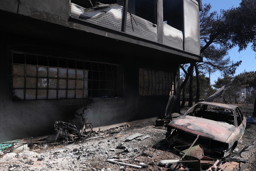 Καμένο κτίριο και αυτοκίνητο μετά τη πυρκαγιά που ξέσπασε στο Νταού Πεντέλης και πήρε ανεξέλεγκτες διαστάσεις