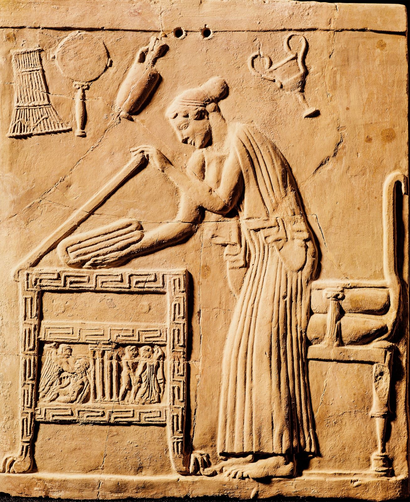 Ανάγλυφο του 5ου π.Χ. αιώνα με μία γυναίκα τοποθετεί το ρούχο της σε κασέλα