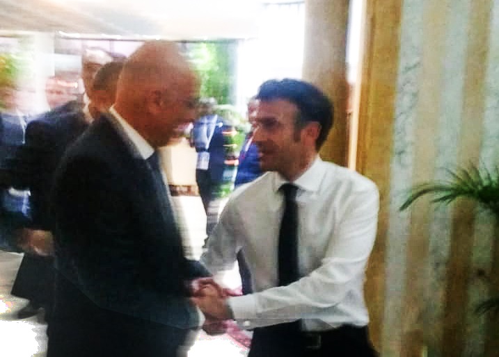 O Νίκος Δένδιας και ο Εμανουέλ Μακρόν ανταλλάσσουν χειραψία κατά τη διάρκεια της συνόδου του Διεθνή Οργανισμού Γαλλοφωνίας στην Τυνησία
