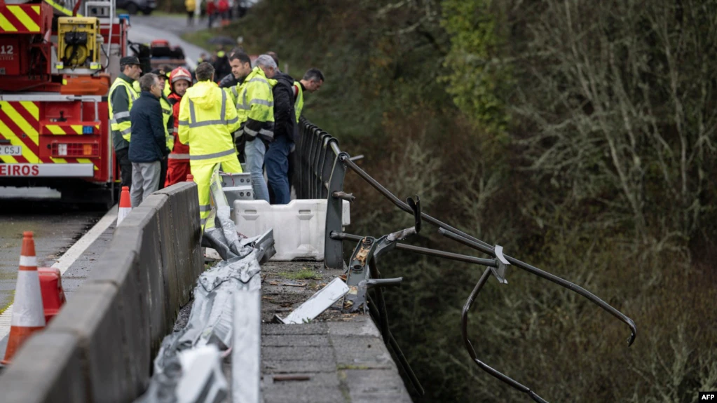 Διασώστες στην Ισπανία πάνω σε γέφυρα κοιτούν στα νέρα του ποταμού ένα λεωφορείο που έχει πέσει σε τροχαίο δυστύχημα με 6 νεκρούς και 2 τραυματίες ανήμερα των Χριστουγέννων