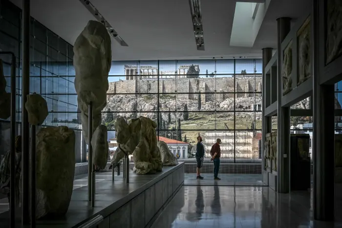 Γλυπτά του Παρθενώνα στο Μουσείο Ακρόπολης με τον ιερό βράχο απέναντι