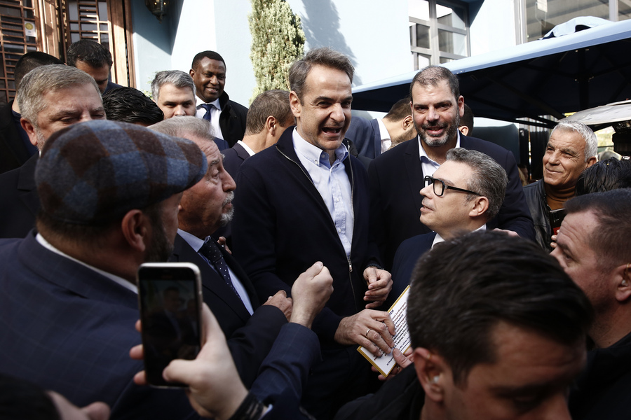 Ο πρωθυπουργός Κυριάκος Μητσοτάκης χαιρετάει κόσμο που τον υποδέχεται κατά τη διάρκεια της επίσκεψής του στον Κορυδαλλό (ΑΠΕ-ΜΠΕ)