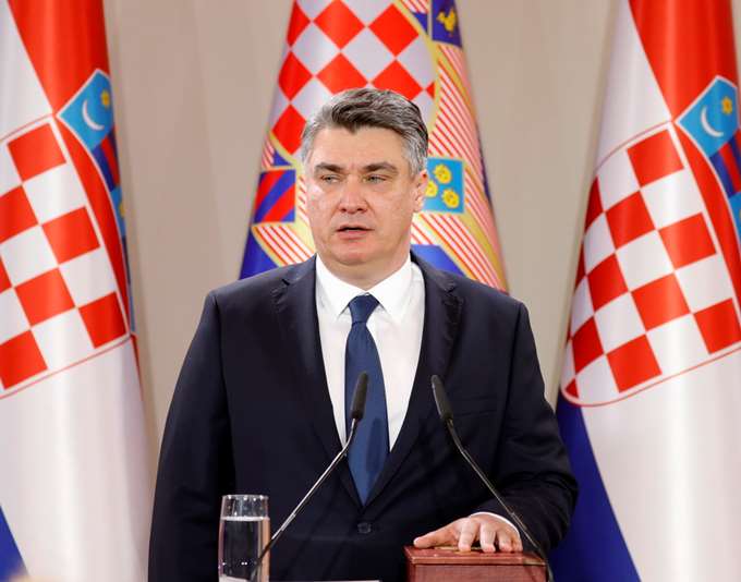 Ο πρόεδρος της Κροατίας Ζόραν Μιλάνοβιτς μπροστά από τρεις σημαίες της χώρας του