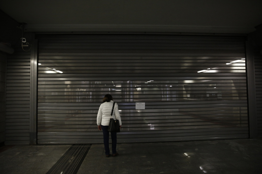 Μια γυναίκα στέκεται μπροστά από την κλειστή είσοδο μετρό κατά τη διάρκεια 24ωρης απεργίας των εργαζομένων (ΑΠΕ-ΜΠΕ)