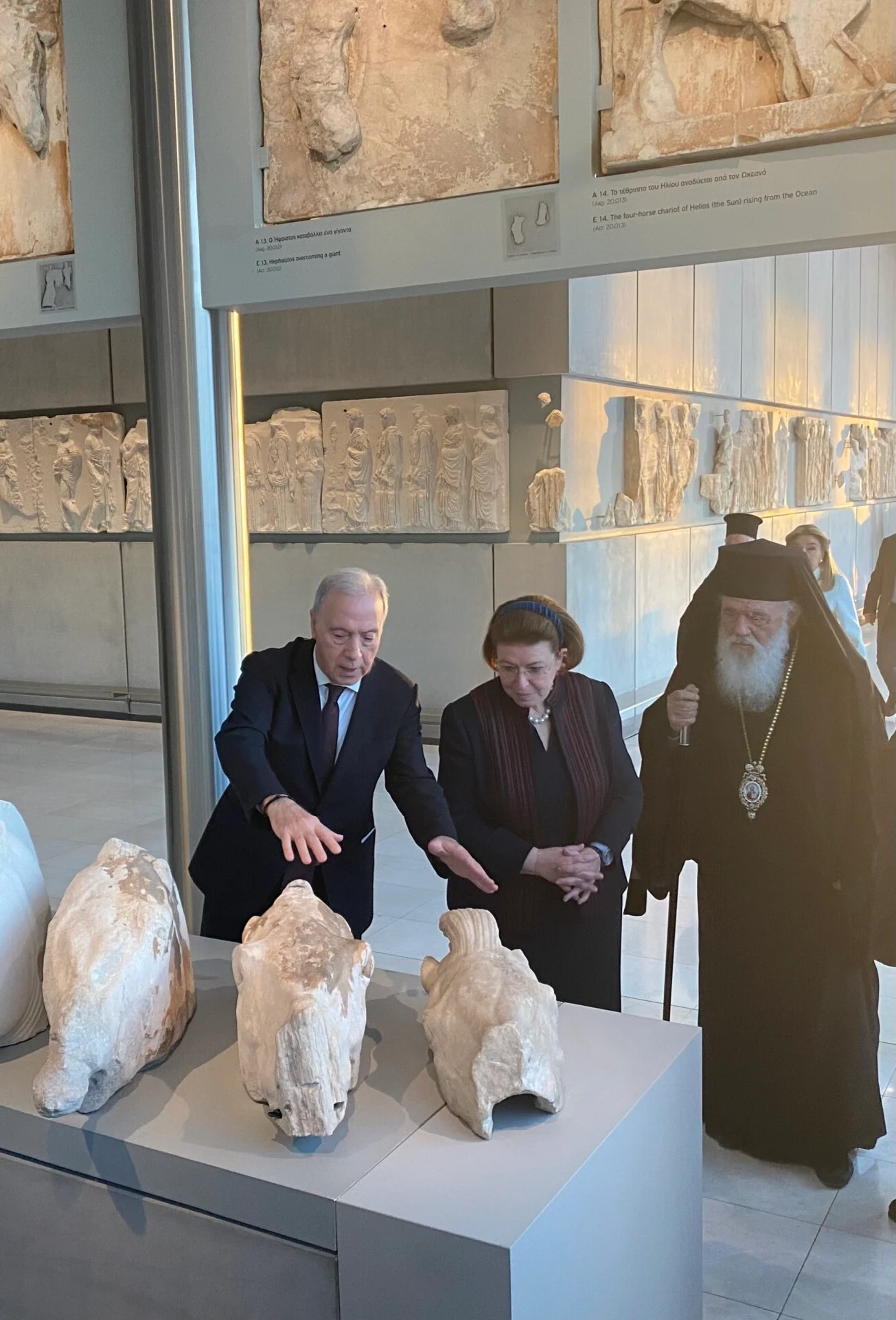 Ο διευθυντής του Μουσείου Ακρόπολης Νίκος Σταμπολίδης, η υπουργός Πολιτισμού Λίνα Μενδώνη και ο Αρχιεπίσκοπος Ιερώνυμος και κατά την επιστροφή θραυσμάτων από το Βατικανό