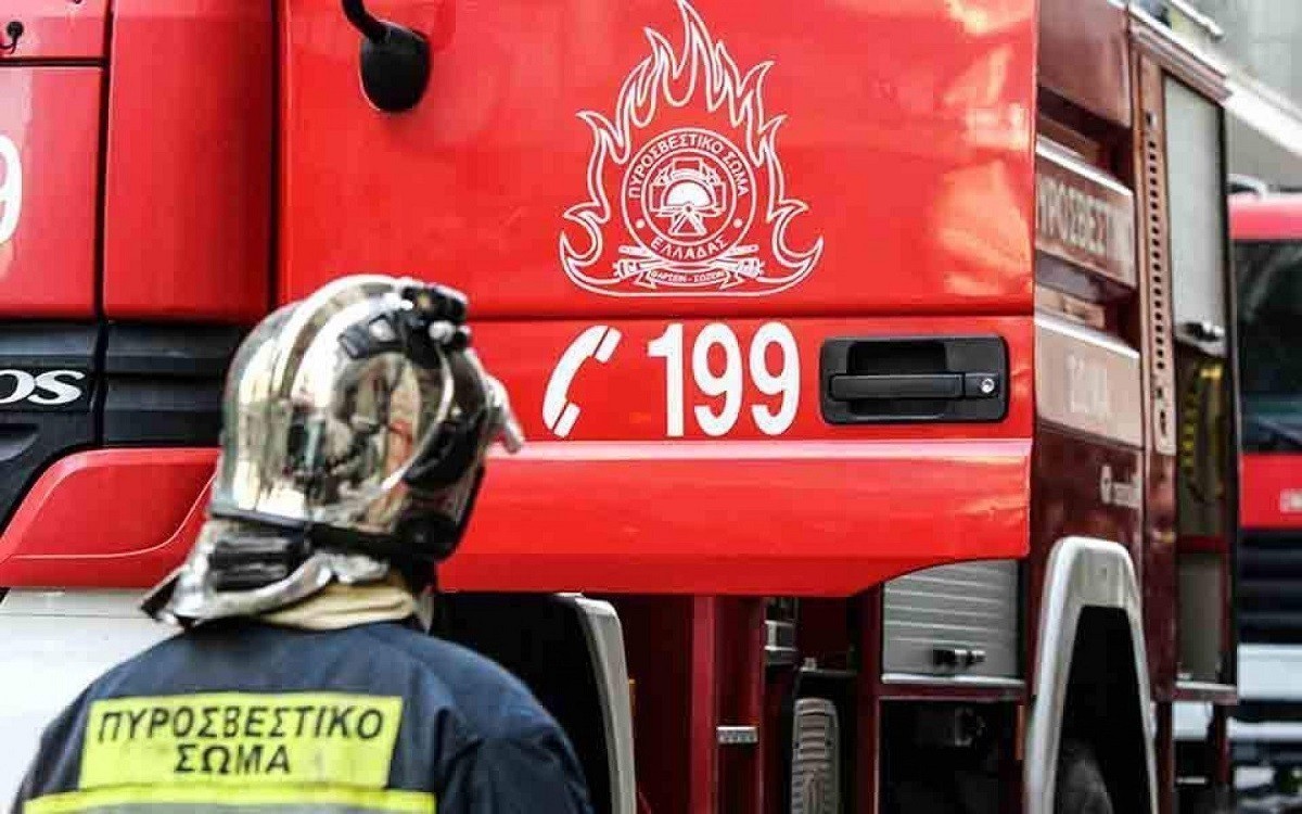 Ένας πυροσβέστης μπροστά από ένα πυροσβεστικό όχημα με τον αριθμό κλήσης 199
