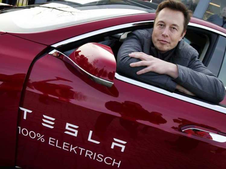 Ο Elon Musk, συνιδρυτής και διευθύνων σύμβουλος της Tesla, ποζάρει σε ένα μοντέλο της εταιρείας