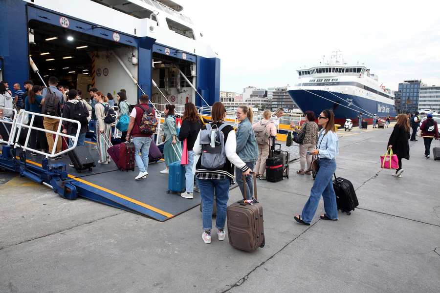 Ταξιδιώτες ετοιμάζονται να επιβιβαστούν σε πλοίο, στο λιμάνι του Πειραιά