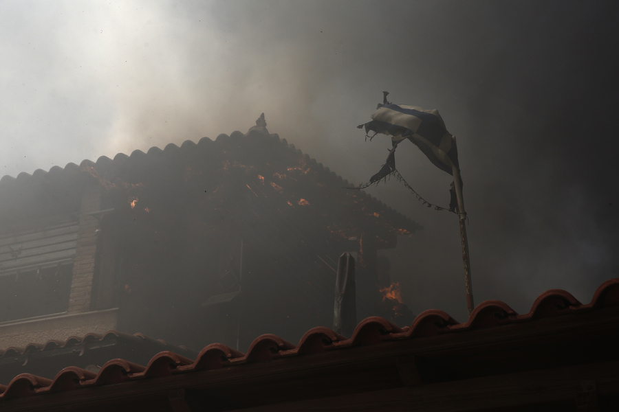 Φωτιά καίει στέγες σπιτιών κατά τη διάρκεια πυρκαγιάς που ξέσπασε στον Κουβαρά Αττικής,