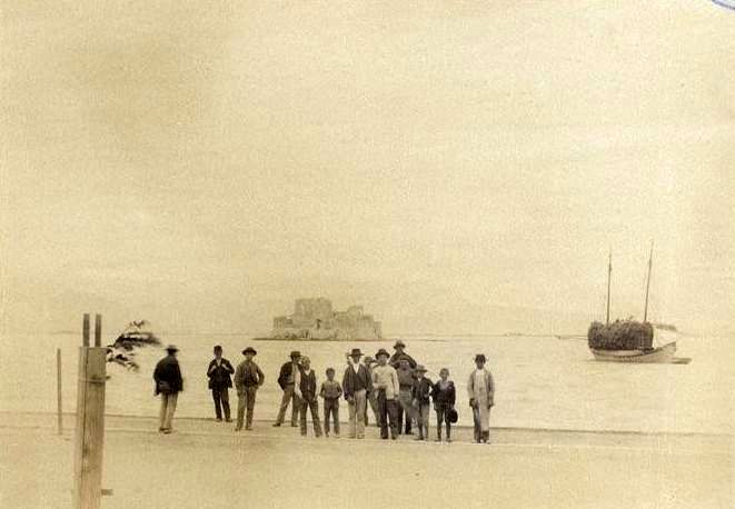 Φωτογραφία του 1892 με κόσμο στην προκυμαία του Ναυπλίου και το Μπούρτζι στο βάθος