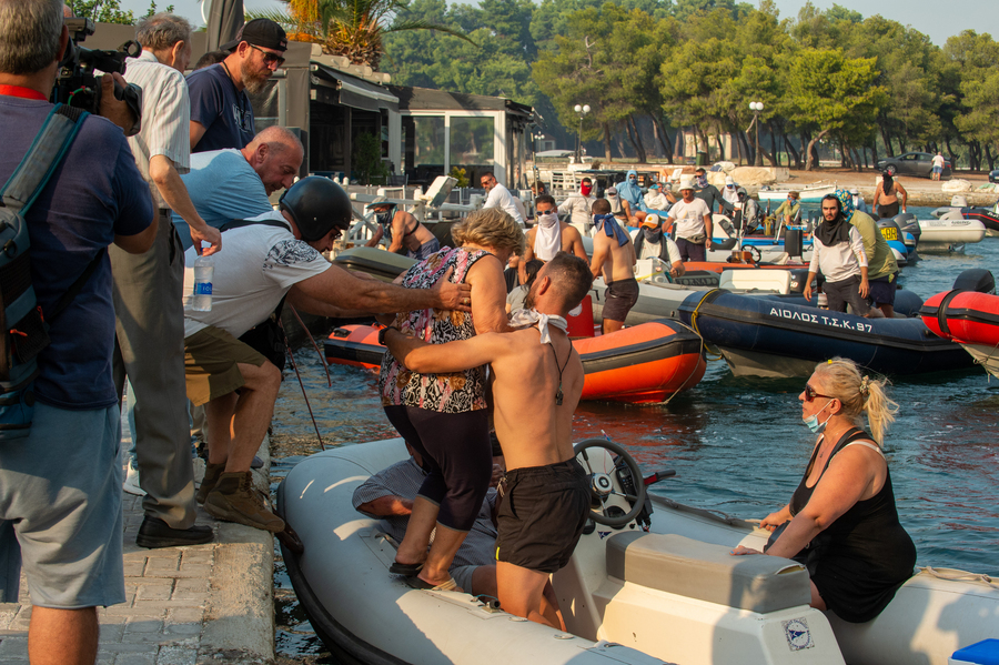 Ιδιωτικά σκάφη απομακρύνουν πολίτες από την παραλία της Νέας Αγχιάλου, εξαιτίας της πυρκαγιάς που έχει περικυκλώσει την περιοχή,