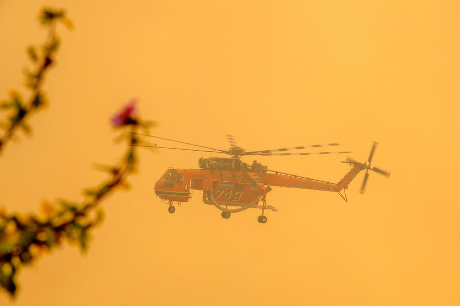 Πυροσβεστικό ελικόπτερο πραγματοποιεί ρίψεις νερού κατά την διάρκεια φωτιάς