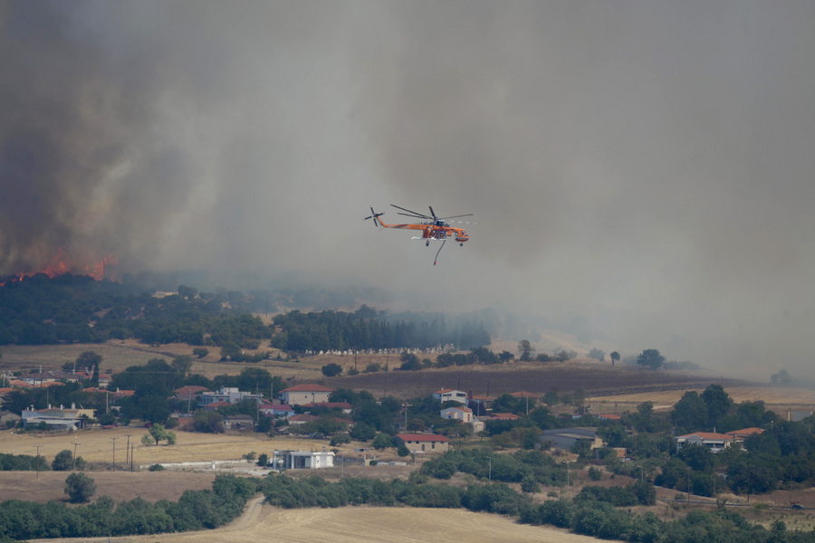 Πυροσβεστικό ελικόπτερο πετάει κατά την διάρκεια κατάσβεσης της φωτιάς σε περιοχή στην Αλεξανδρούπολη