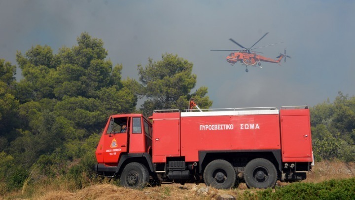 Πυροσβεστικό αεροπλάνο πετά πάνω από Πυροσβεστικό όχημα που βρίσκεται σε σε δάσος