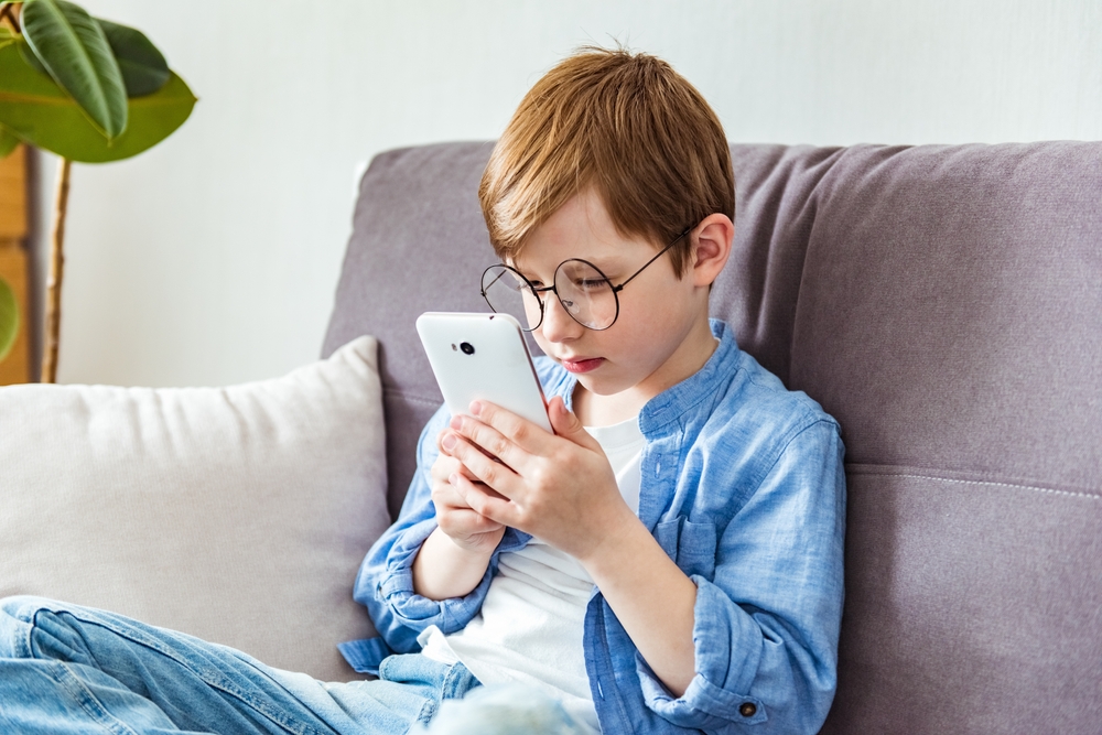 Παιδί με μυωπία περνάει αρκετό χρόνο μπροστά στην οθόνη του κινητού