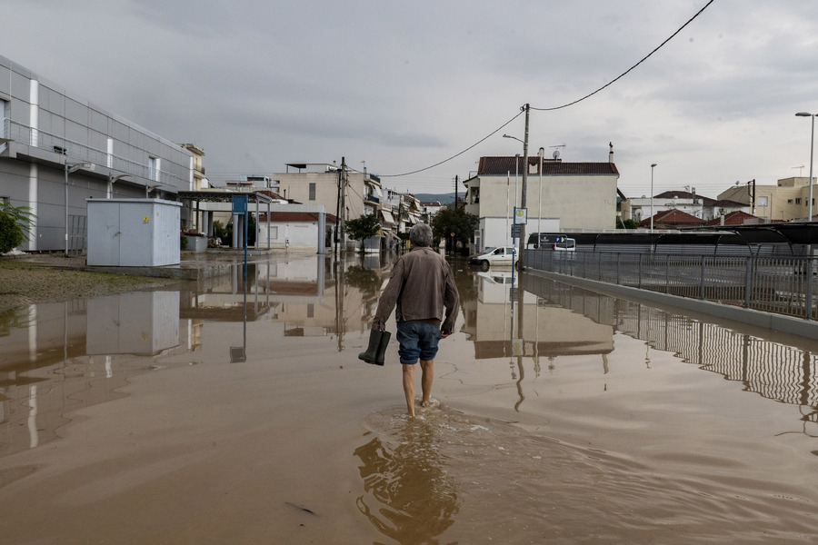Βόλος: Κάτοικος διασχίζει πλημμυρισμένο δρόμο μετά το πέρασμα της κακοκαιρίας Elias στην περιοχή Νεάπολη Βόλου