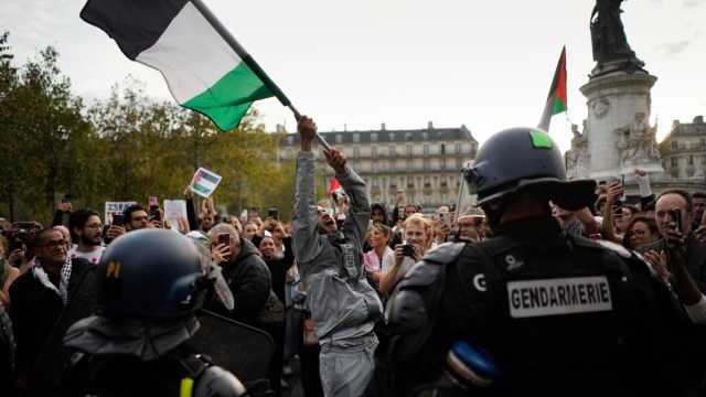 αστυνομικοί επιτηρούν διαδηλωτές με παλαιστινιακές σημαίες στο Παρίσι