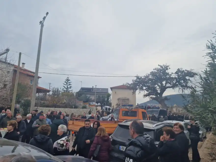 Πολίτες της Χειμμάρας περιμένουν τον δήμαρχο Φρέντι Μπελέρη που μεταφέρεται από στυνομικούς στην κηδεία της γιαγιάς του