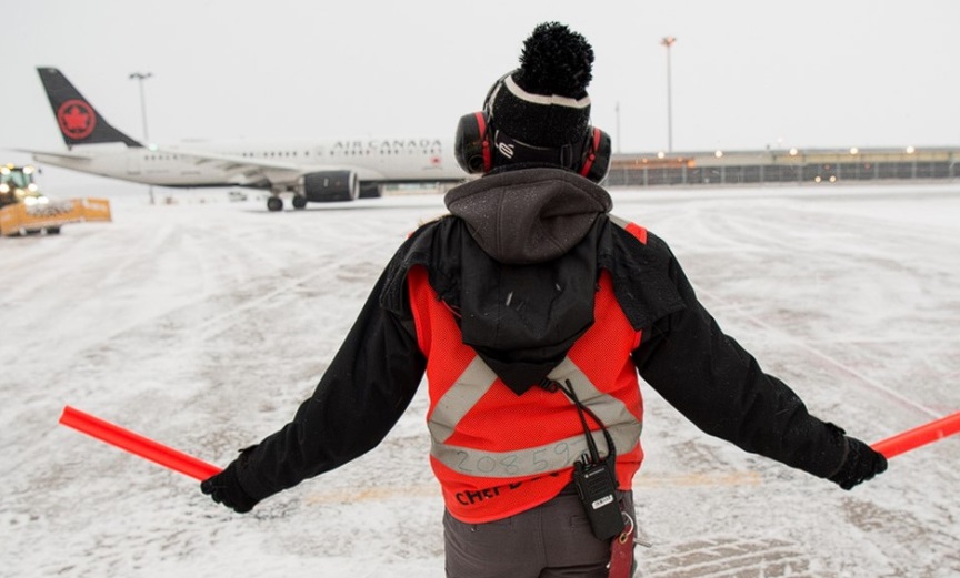 Υπάλληλος του αεροδρομίου του Βανκούβερ στο χιονισμένο αεροδρόμιο το 2022 - Φωτογραφία αρχείου