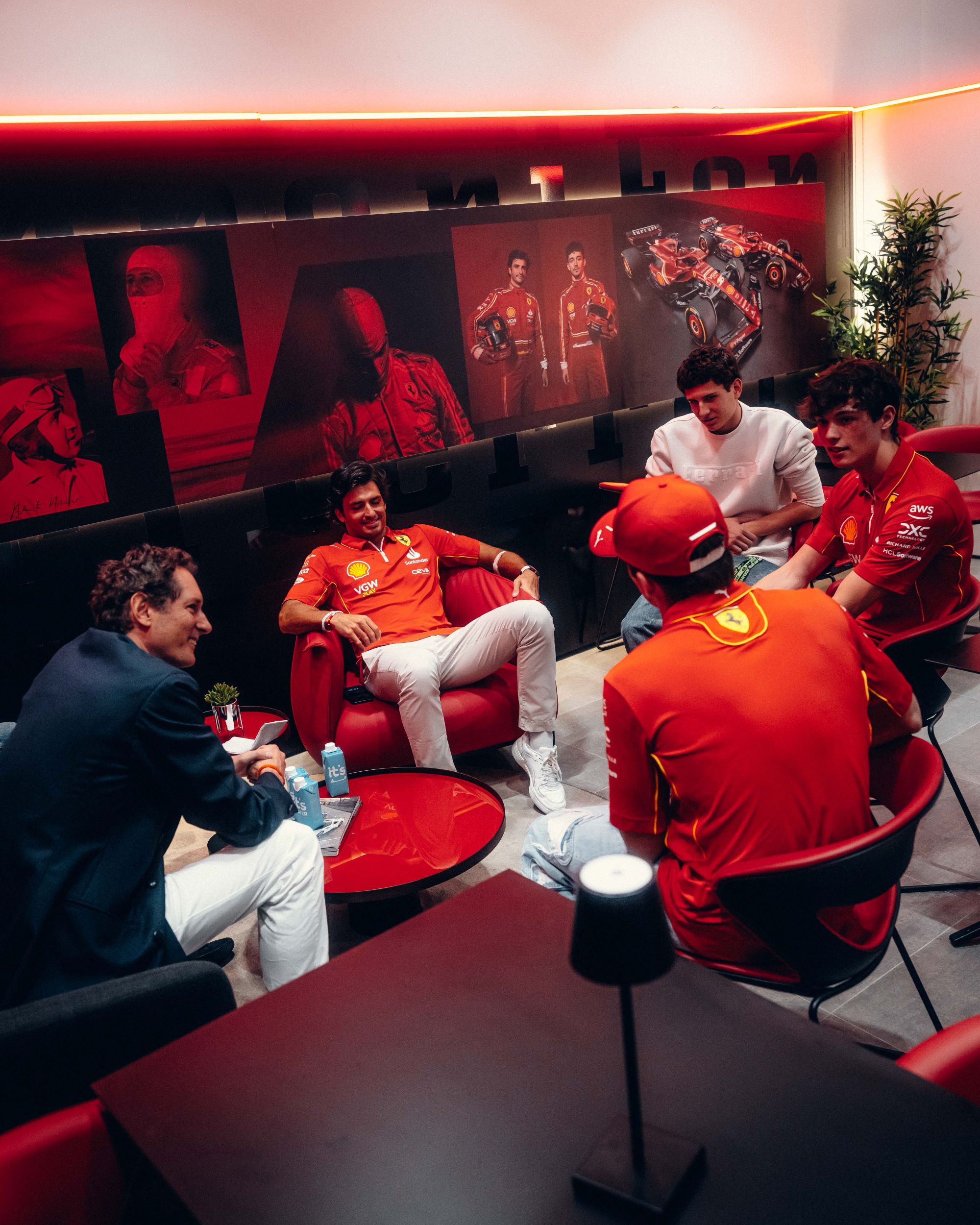 Ο Elkann αριστερά μιλά με τους οδηγούς της ομάδας: Sainz, Bearman, Leclerc.