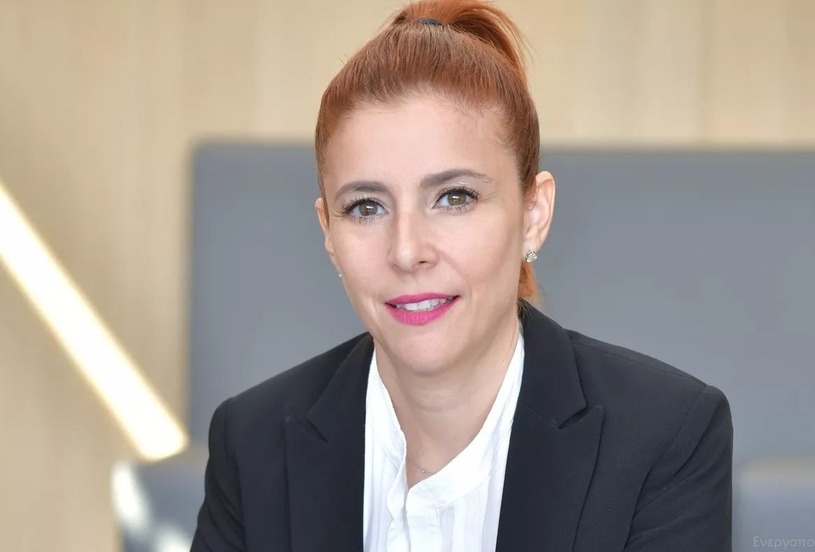 A woman with red hair wearing a black blazer indoors