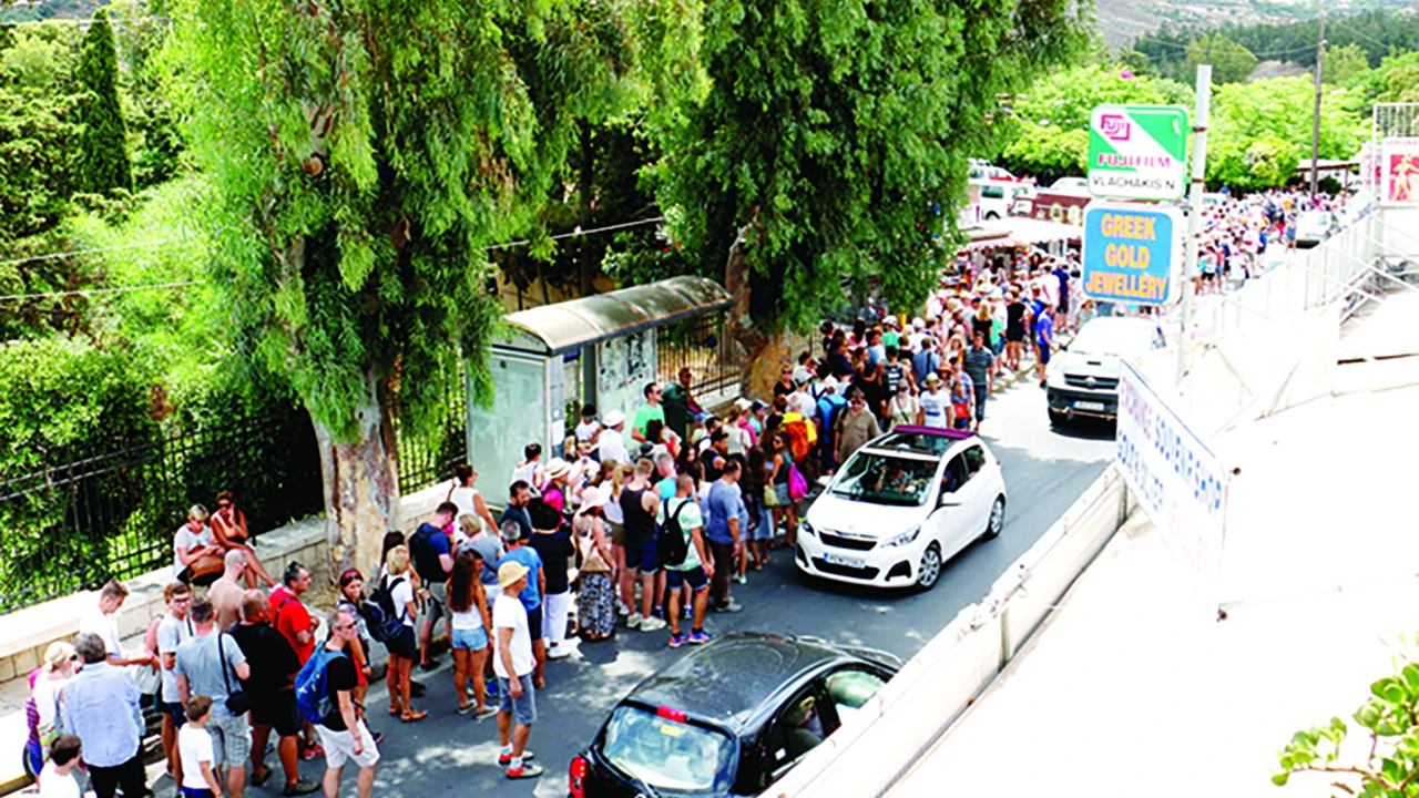 Στον δρόμο της εισόδου του αρχαιολογικού χώρου, τουρίστες, αυτοκίνητα και τουριστικά είδη σε μία χαοτική συνύπαρξη