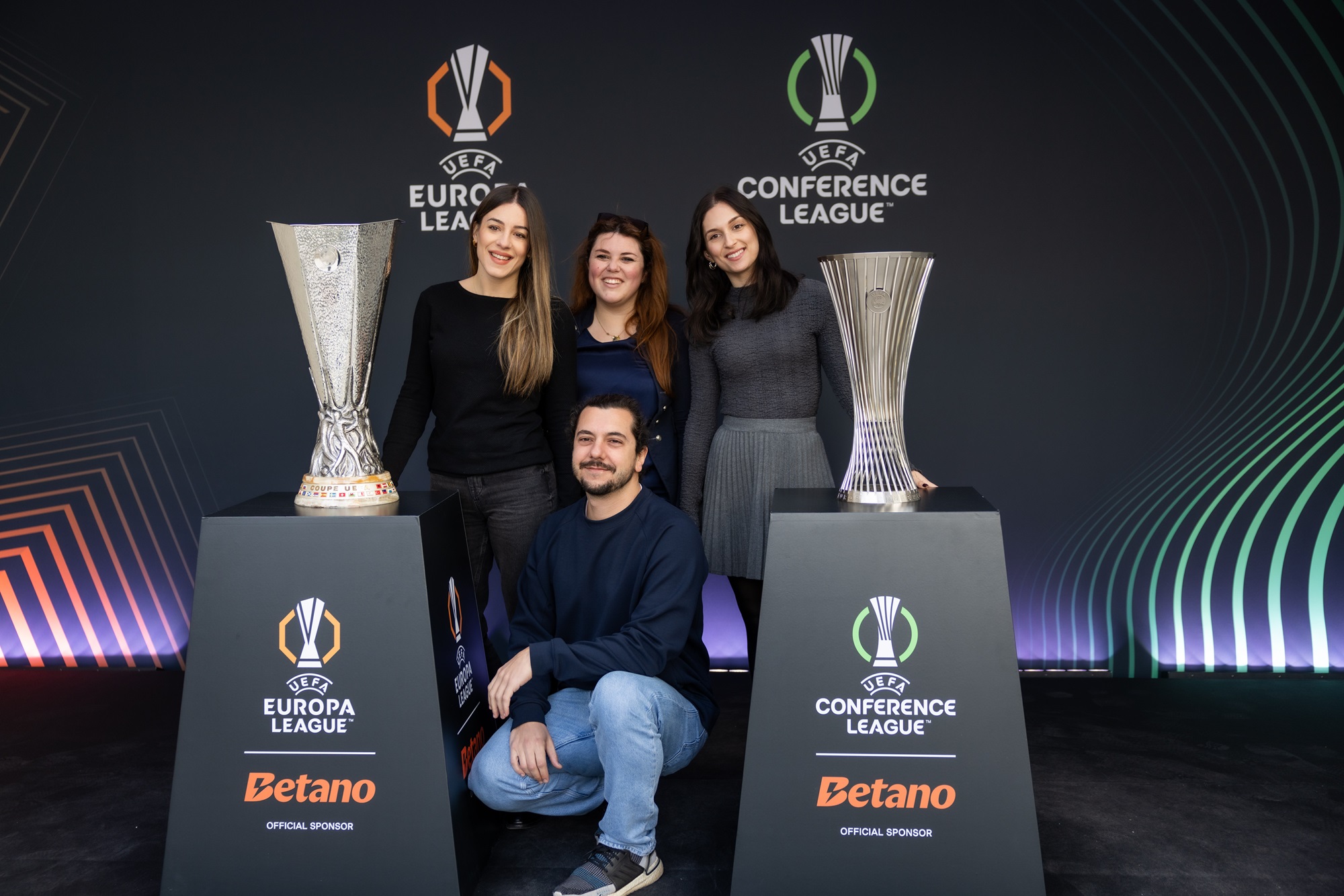 : Εργαζόμενοι της Kaizen Gaming στο Kaizen Campus στην Αθήνα φωτογραφίζονται με τα δύο τρόπαια.