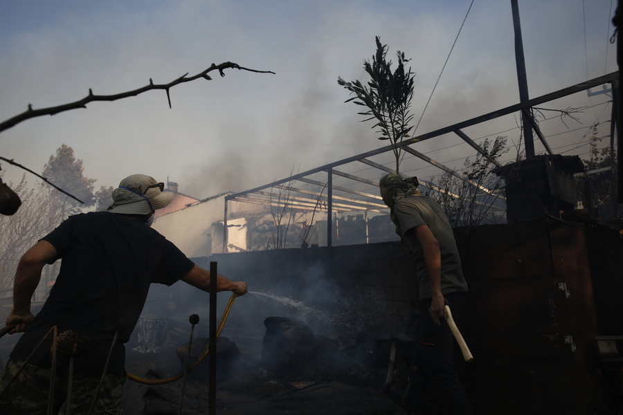 Εθελοντές επιχειρούν στην κατάσβεση φωτιάς που καίει σπίτι στο Κρυονέρι Αττικής