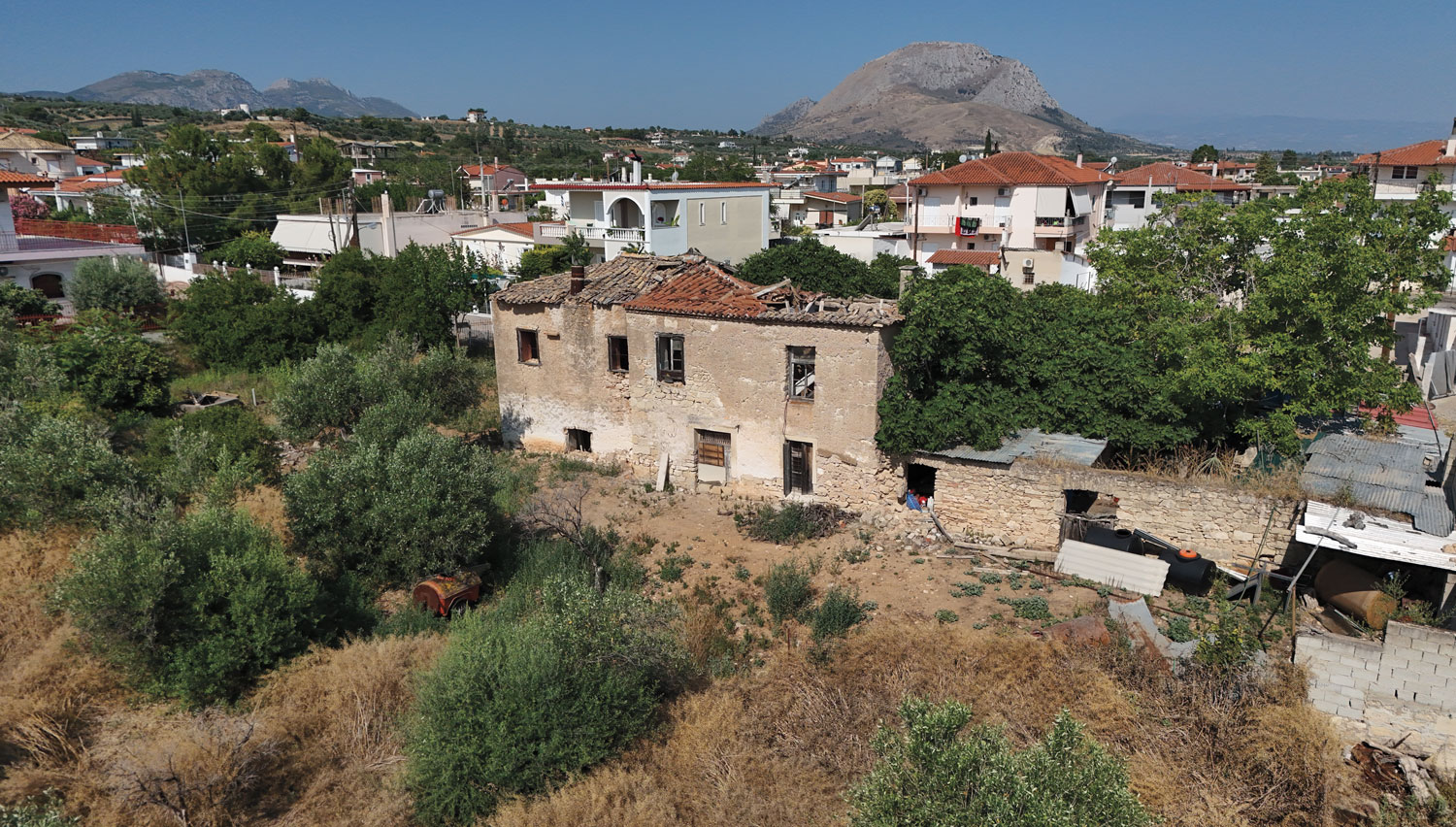 Μονώροφο κτίσμα (δεξιά) σε ερειπιώδη κατάσταση στο χωριό Εξαμίλια, που θεωρείται ότι ήταν μέρος του οικισμού της Ουασινγκτόνιας