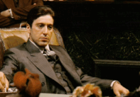 Αυτή η εικόνα είναι από την ταινία «The Godfather» (Ο Νονός, 1972) και δείχνει τον Michael Corleone, τον νεαρό γιο της οικογένειας Κορλεόνε, καθισμένο στο γραφείο του, σε μια σκηνή που υποδηλώνει την ανάληψη ευθύνης και εξουσίας μέσα στην οικογένεια.