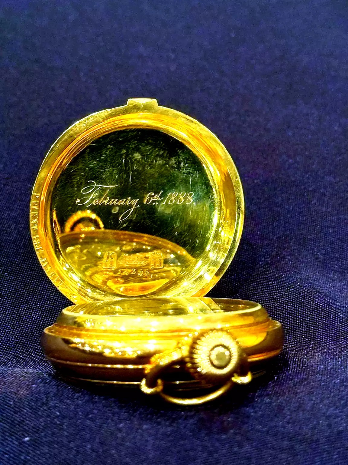 Χρυσό ρολόι τσέπης 18 καρατίων με λευκό καντράν, μαύρους αριθμούς και δευτερεύον καντράν σε σκούρο φόντο,  ιδιοκτησίας του επιβάτη του Τιτανικού Ίζιντορ Στράους